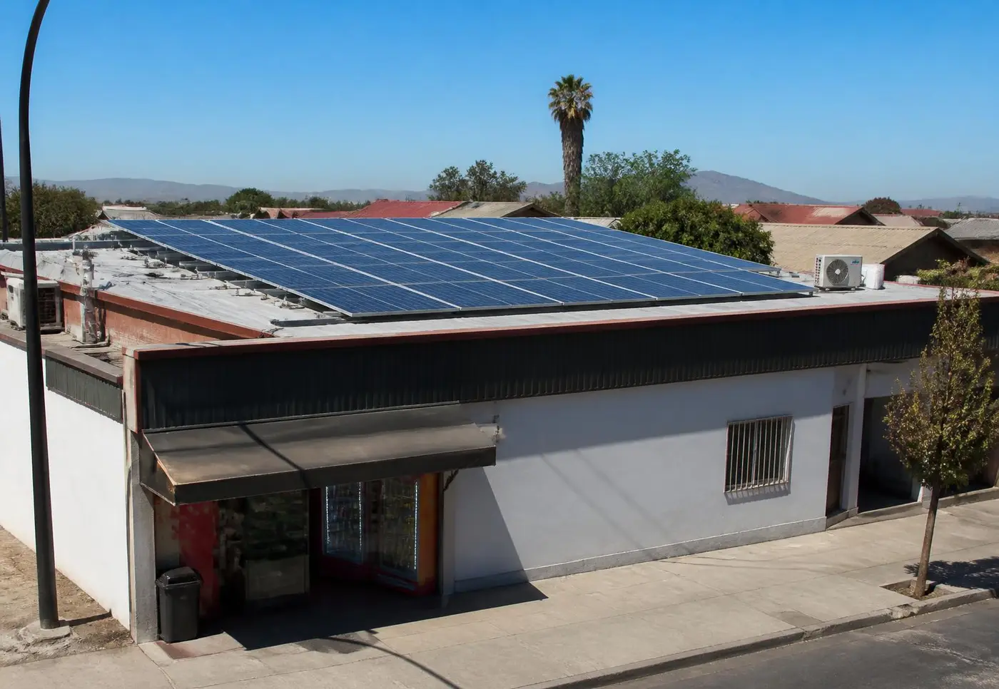 Comercio chileno con paneles solares instalados en su techo bajo sol de mediodía